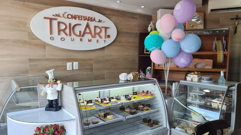 Interior da Trigart com letreiro na parede amadeirada e vitrines.