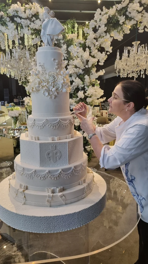 Michaela Fonseca trabalhando na decoração de um bolo de casamento